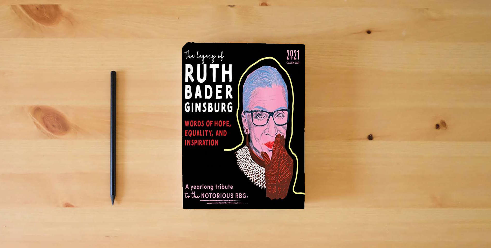The book 2021 The Legacy of Ruth Bader Ginsburg Wall Calendar: Her Words of Hope, Equality and Inspiration ― A yearlong tribute to the notorious RBG (12-Month Monthly Calendar) is on the table