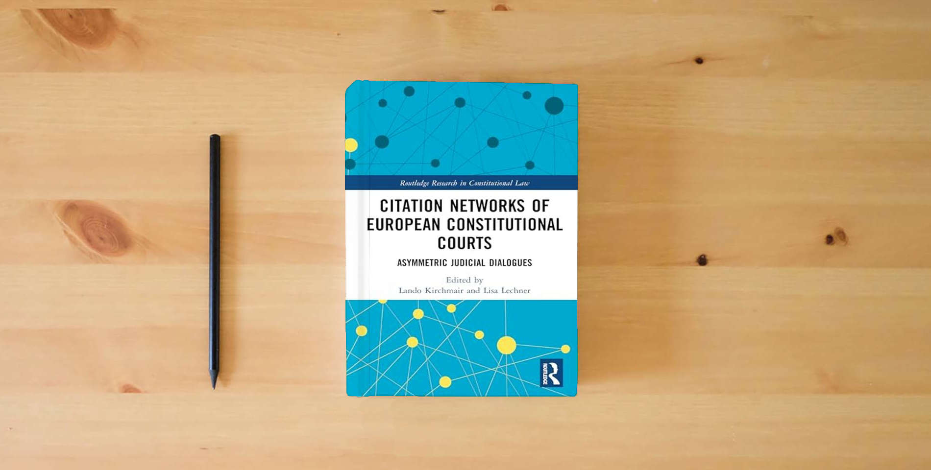The book Citation Networks of European Constitutional Courts: Asymmetric Judicial Dialogues (Routledge Research in Constitutional Law) is on the table