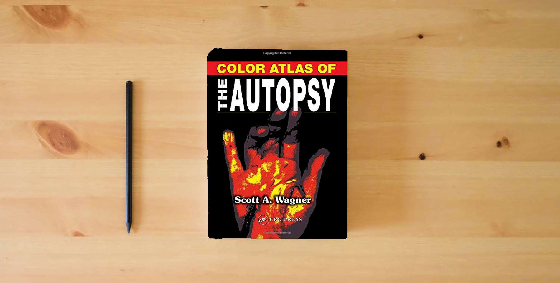 The book Color Atlas of the Autopsy is on the table