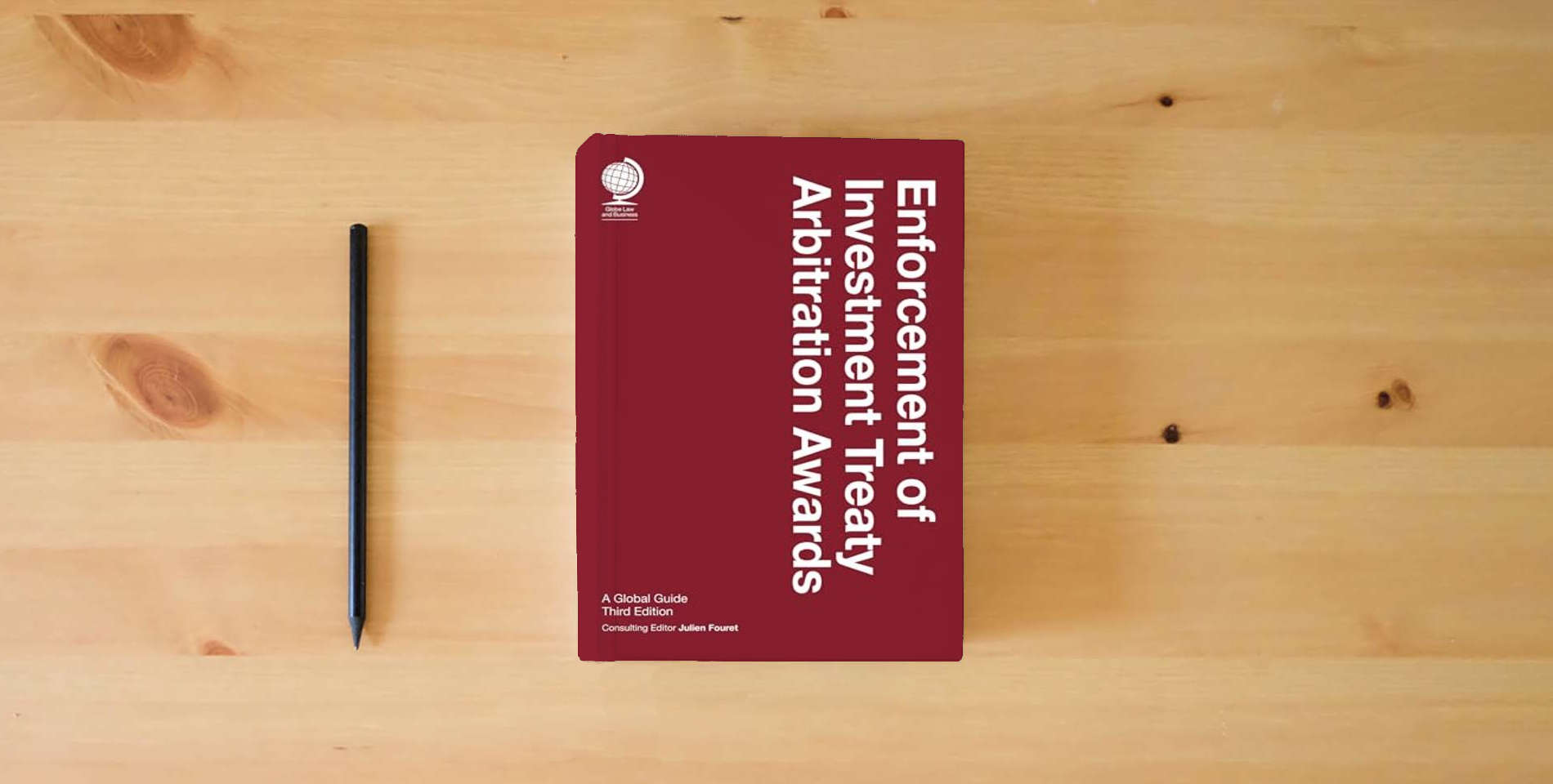 The book Enforcement of Investment Treaty Arbitration Awards, Third Edition is on the table