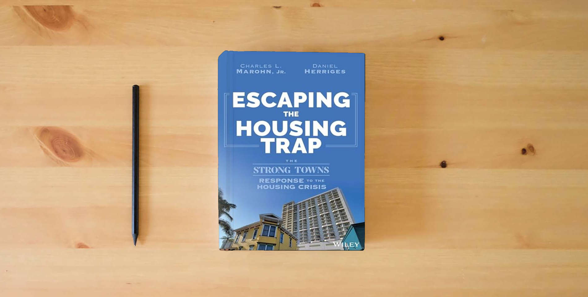 The book Escaping the Housing Trap: The Strong Towns Response to the Housing Crisis is on the table