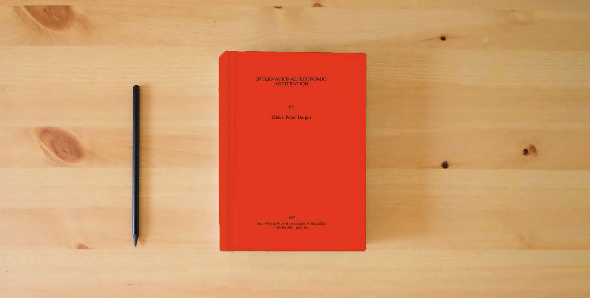 The book International Economic Arbitration (STUDIES IN TRANSNATIONAL ECONOMIC LAW) is on the table