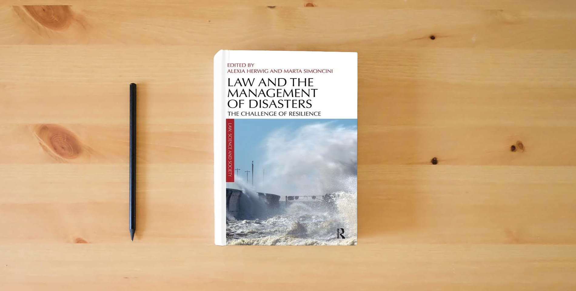 The book Law and the Management of Disasters (Law, Science and Society) is on the table