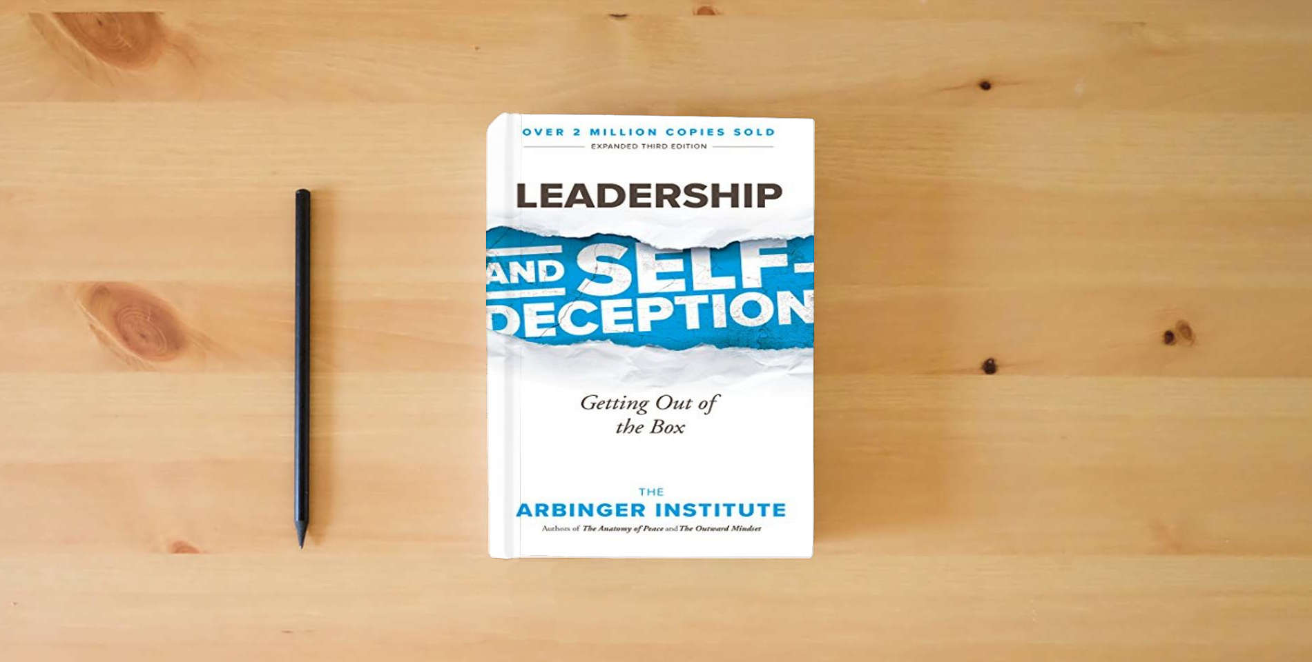 The book Leadership and Self-Deception: Getting Out of the Box is on the table