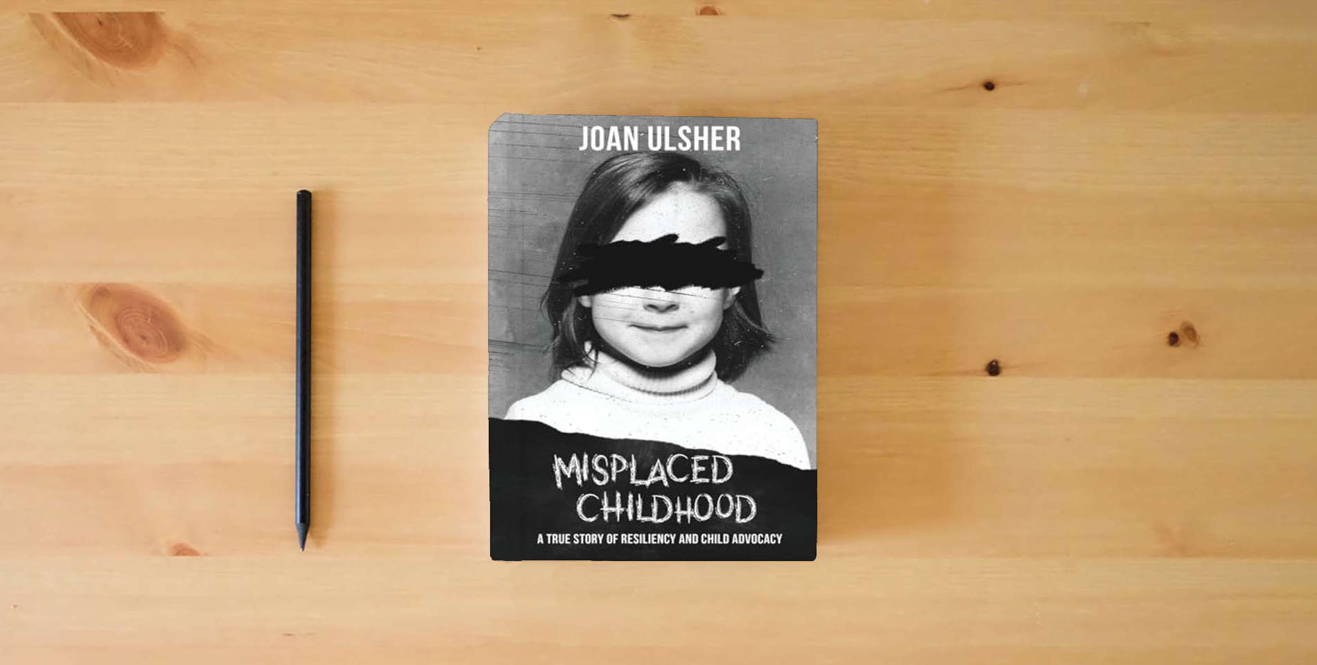 The book MISPLACED CHILDHOOD: A TRUE STORY OF RESILIENCY AND CHILD ADVOCACY is on the table