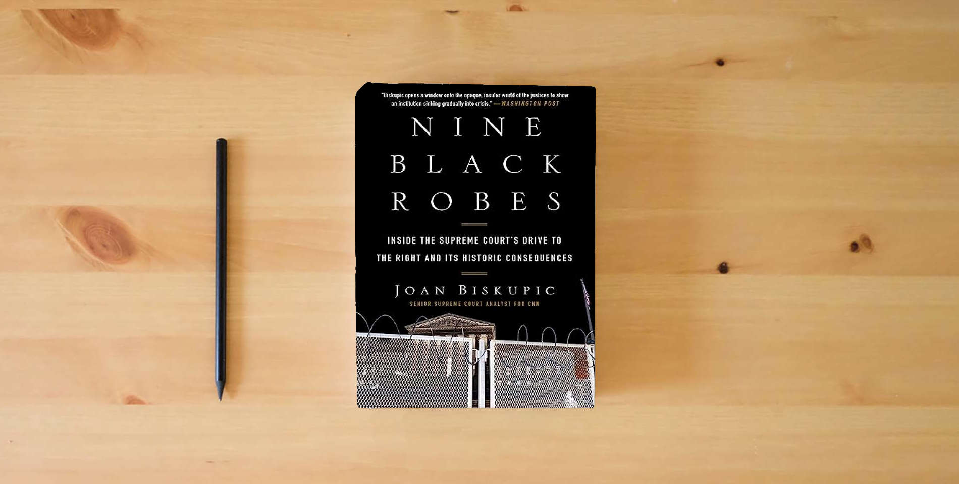 The book Nine Black Robes: Inside the Supreme Court's Drive to the Right and Its Historic Consequences is on the table