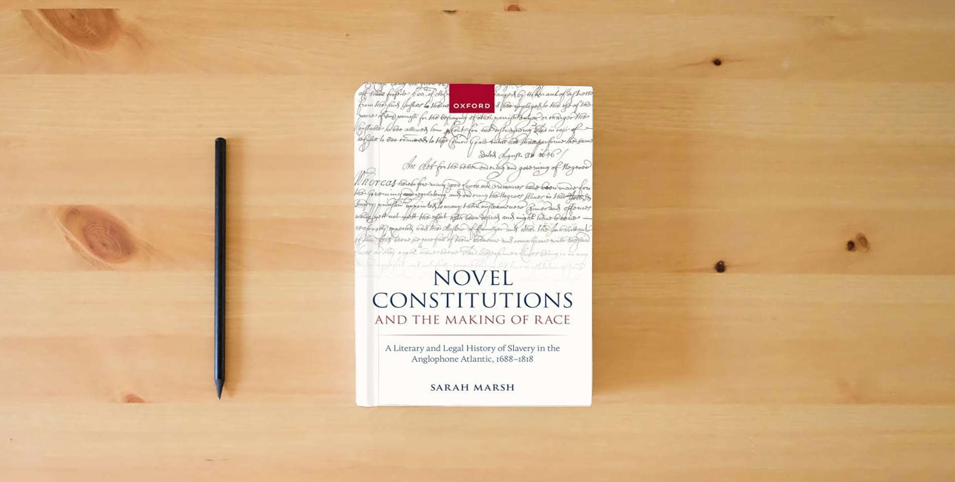 The book Novel Constitutions and the Making of Race: A Literary and Legal History of Slavery in the Anglophone Atlantic, 1688–1818 (Law and Literature) is on the table