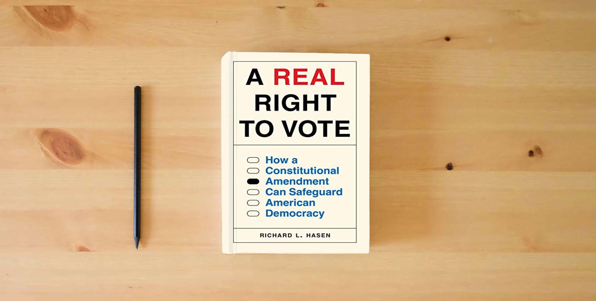 The book A Real Right to Vote: How a Constitutional Amendment Can Safeguard American Democracy is on the table