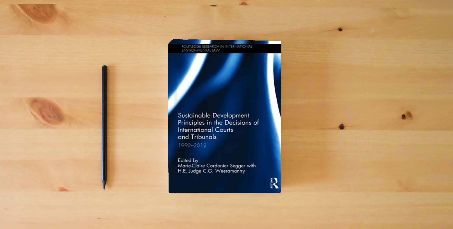 The book Sustainable Development Principles in the Decisions of International Courts and Tribunals: 1992-2012 (Routledge Research in International Environmental Law) is on the table