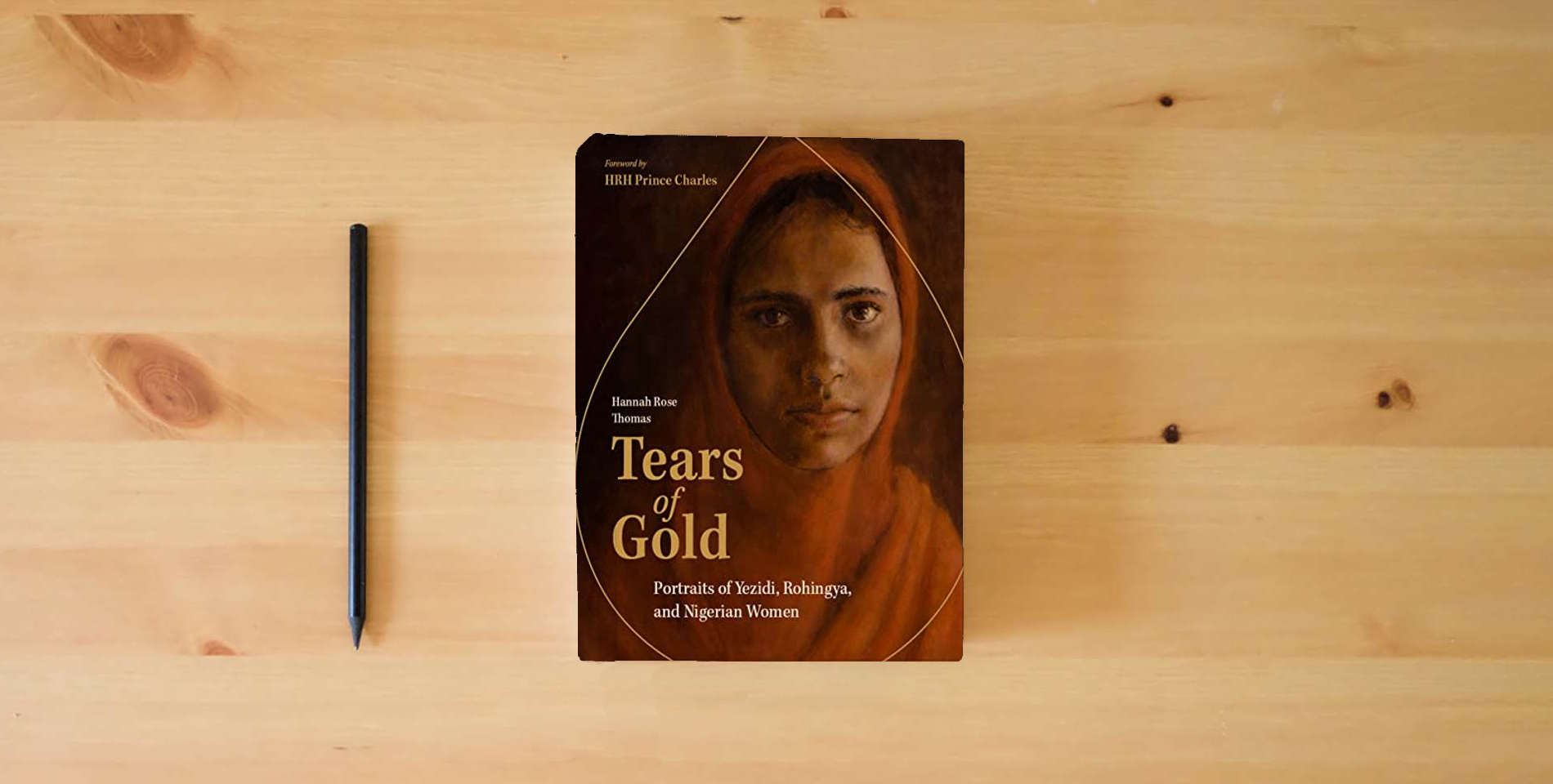 The book Tears of Gold: Portraits of Yezidi, Rohingya, and Nigerian Women is on the table