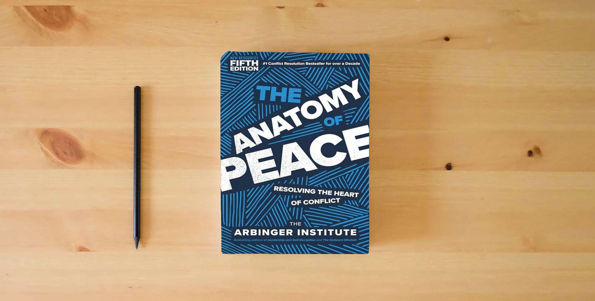 The book The Anatomy of Peace, Fifth Edition: Resolving the Heart of Conflict is on the table