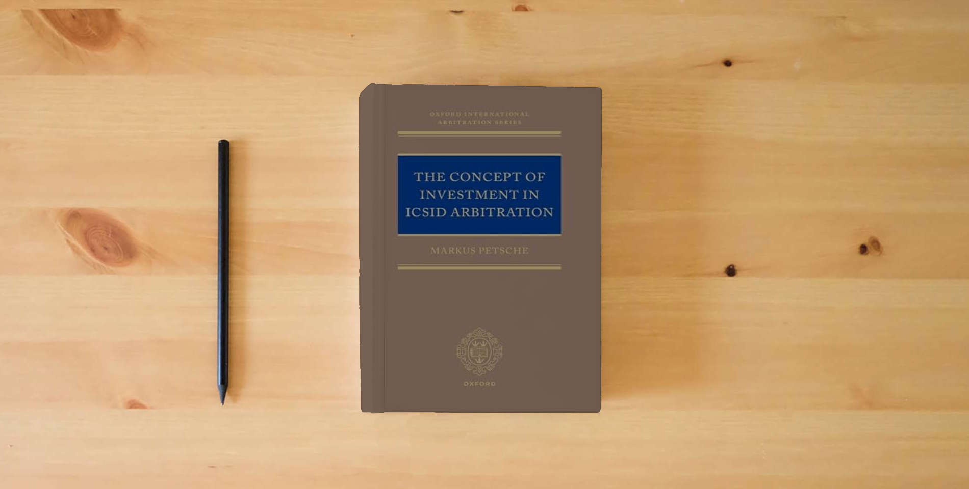 The book The Concept of Investment in ICSID Arbitration (Oxford International Arbitration Series) is on the table