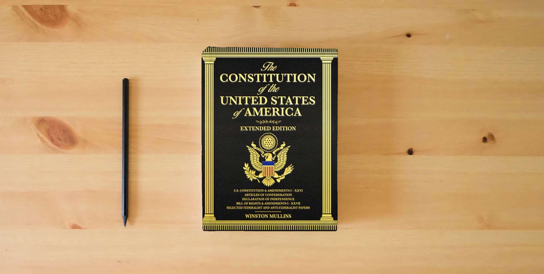 The book The Constitution of the United States of America, Extended Edition: A Complete Reference Guide with Detailed Explanations of the U.S. Constitution, Declaration of Independence, and Bill of Rights is on the table