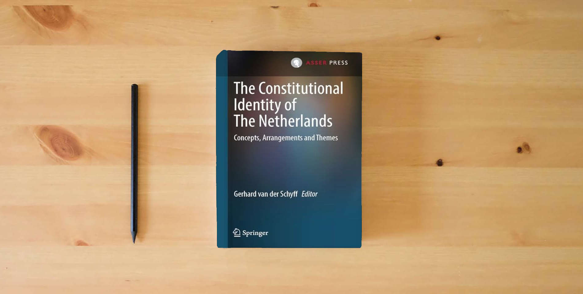 The book The Constitutional Identity of The Netherlands: Concepts, Arrangements and Themes is on the table