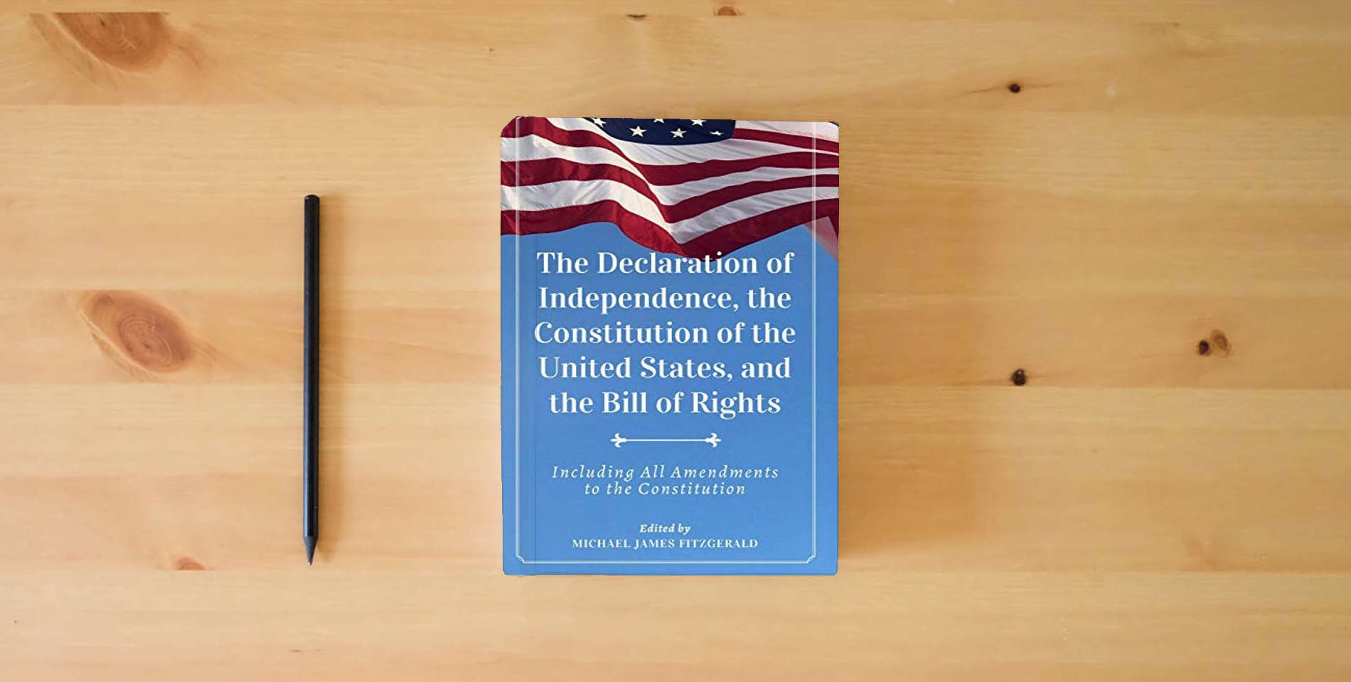 The book The Declaration of Independence, The Constitution of the United States, and The Bill of Rights is on the table