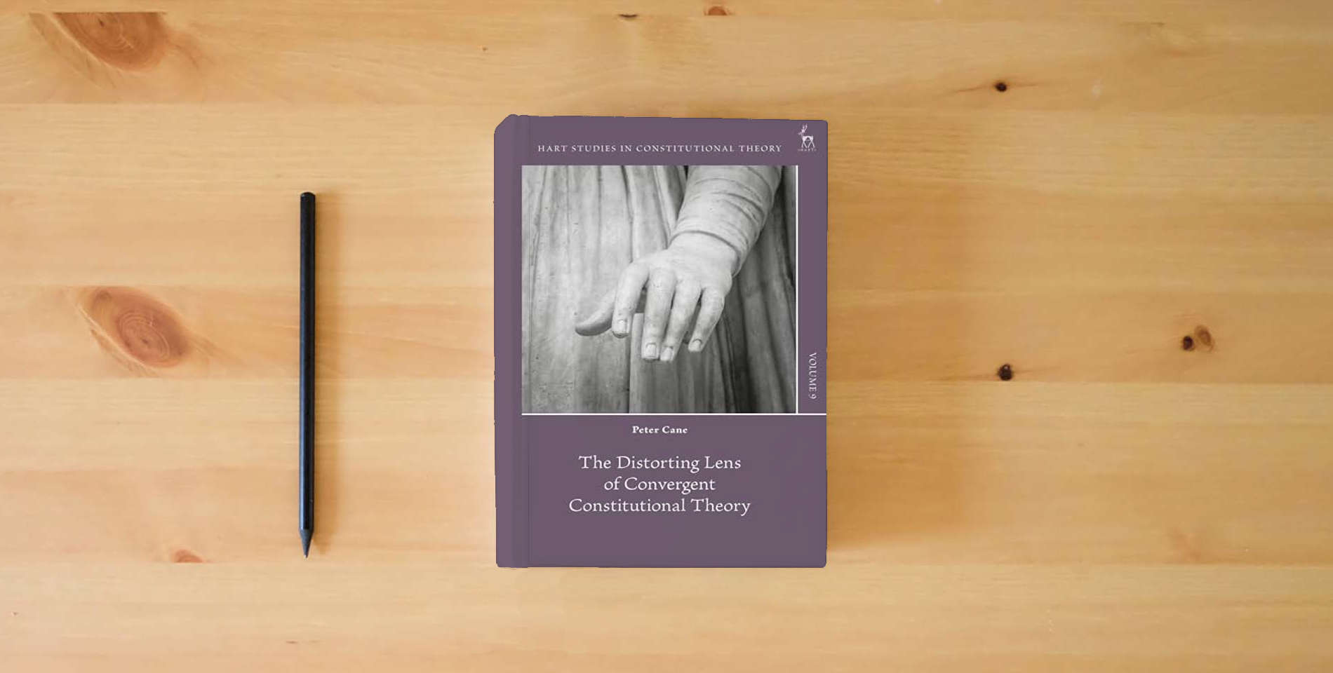 The book The Distorting Lens of Convergent Constitutional Theory (Hart Studies in Constitutional Theory) is on the table