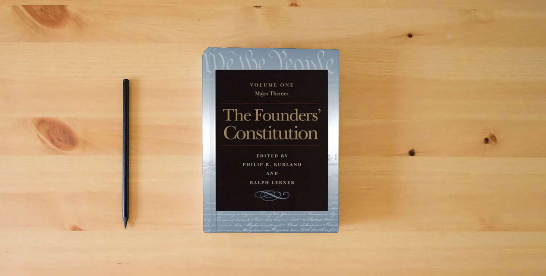 The book The Founders' Constitution (5 Volume Set) is on the table