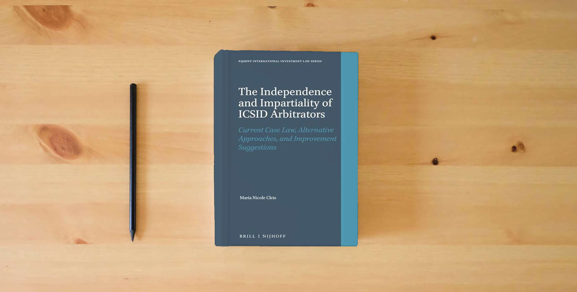 The book The Independence and Impartiality of ICSID Arbitrators: Current Case Law, Alternative Approaches, and Improvement Suggestions (Nijhoff International Investment Law Series, 8) is on the table
