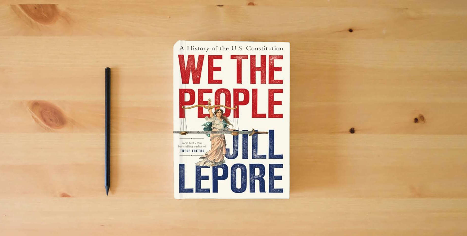 The book We the People: A History of the U.S. Constitution is on the table