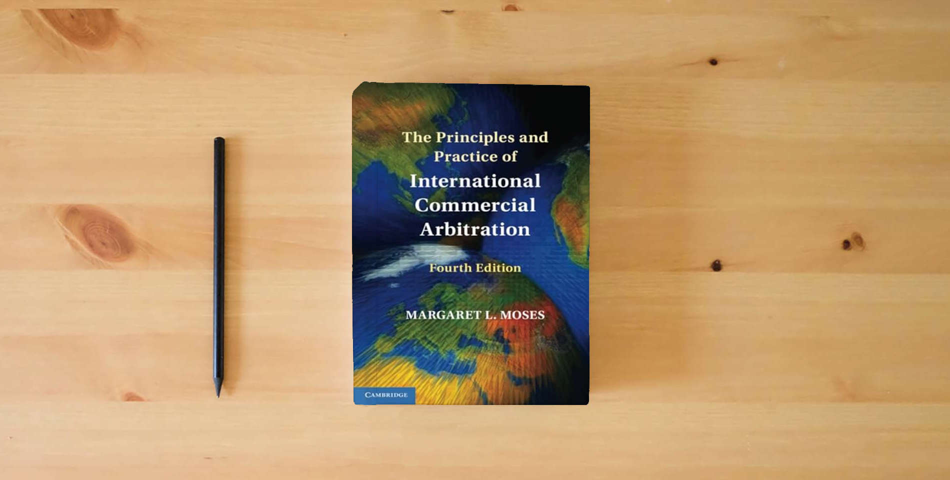 The book The Principles and Practice of International Commercial Arbitration is on the table