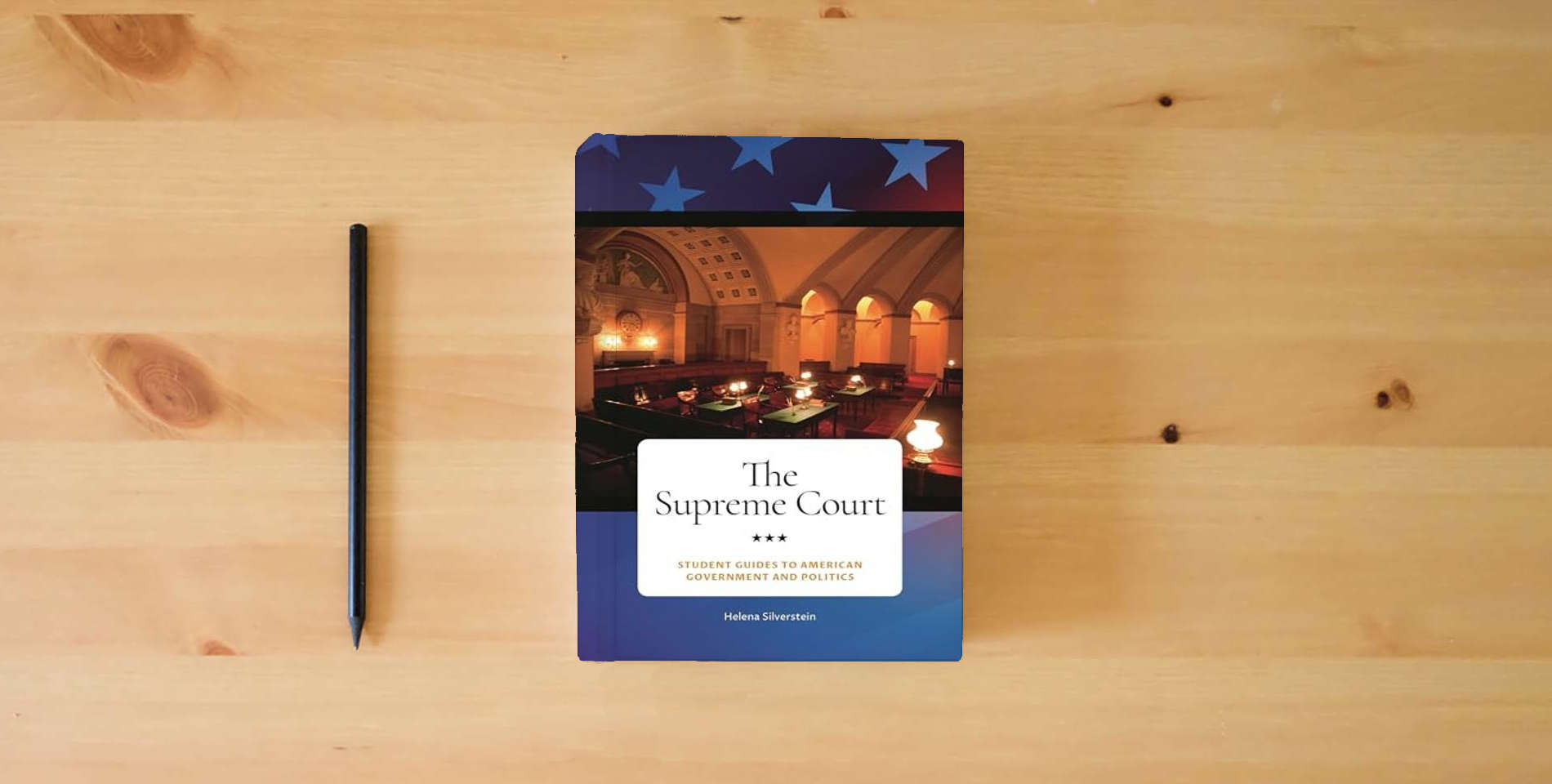 The book The Supreme Court (Student Guides to American Government and Politics) is on the table