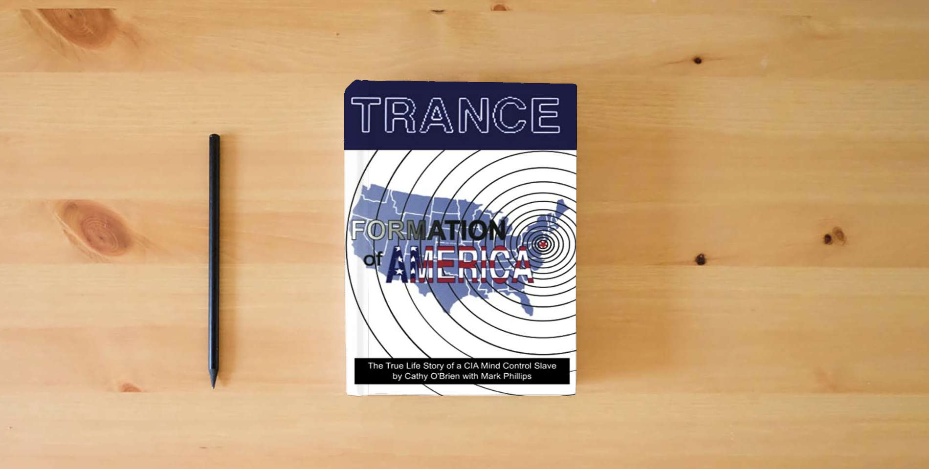 The book Trance Formation of America is on the table