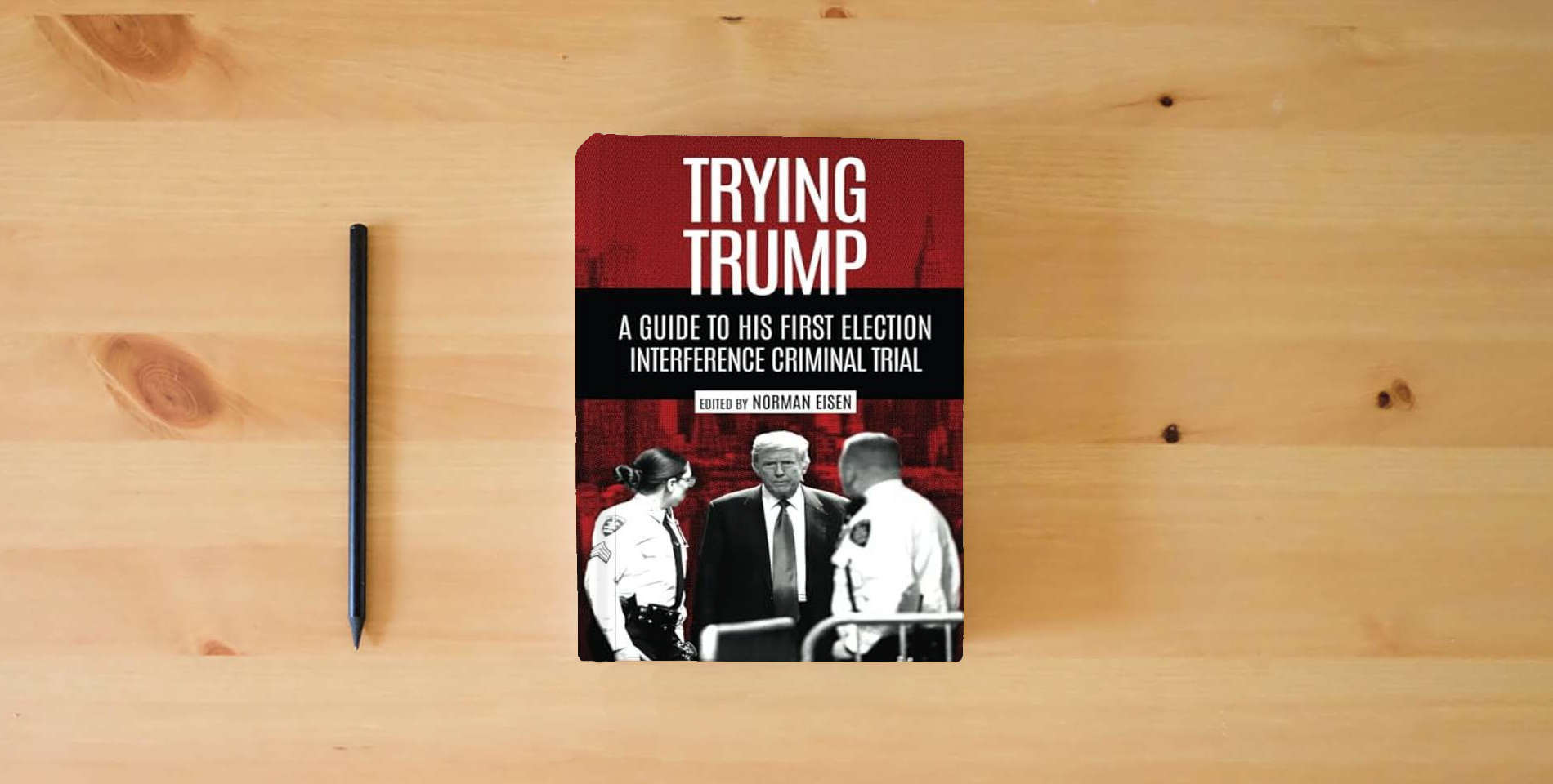 The book Trying Trump: A Guide to His First Election Interference Criminal Trial is on the table