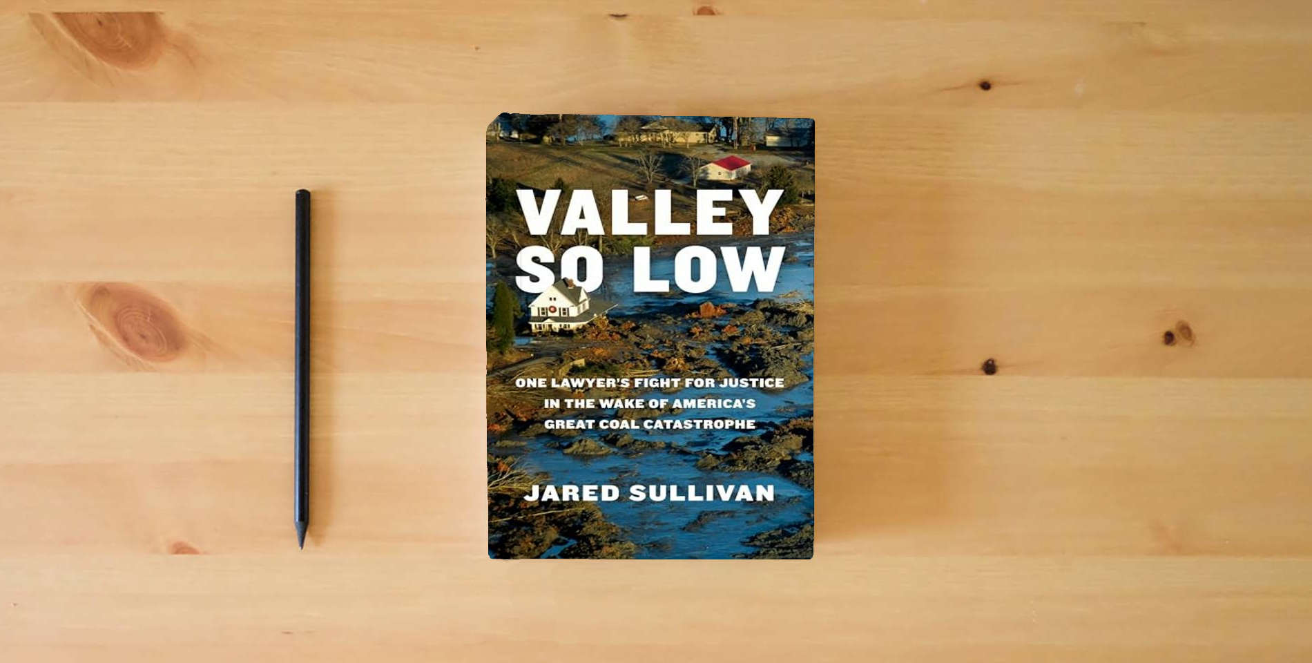 The book Valley So Low: One Lawyer's Fight for Justice in the Wake of America's Great Coal Catastrophe is on the table