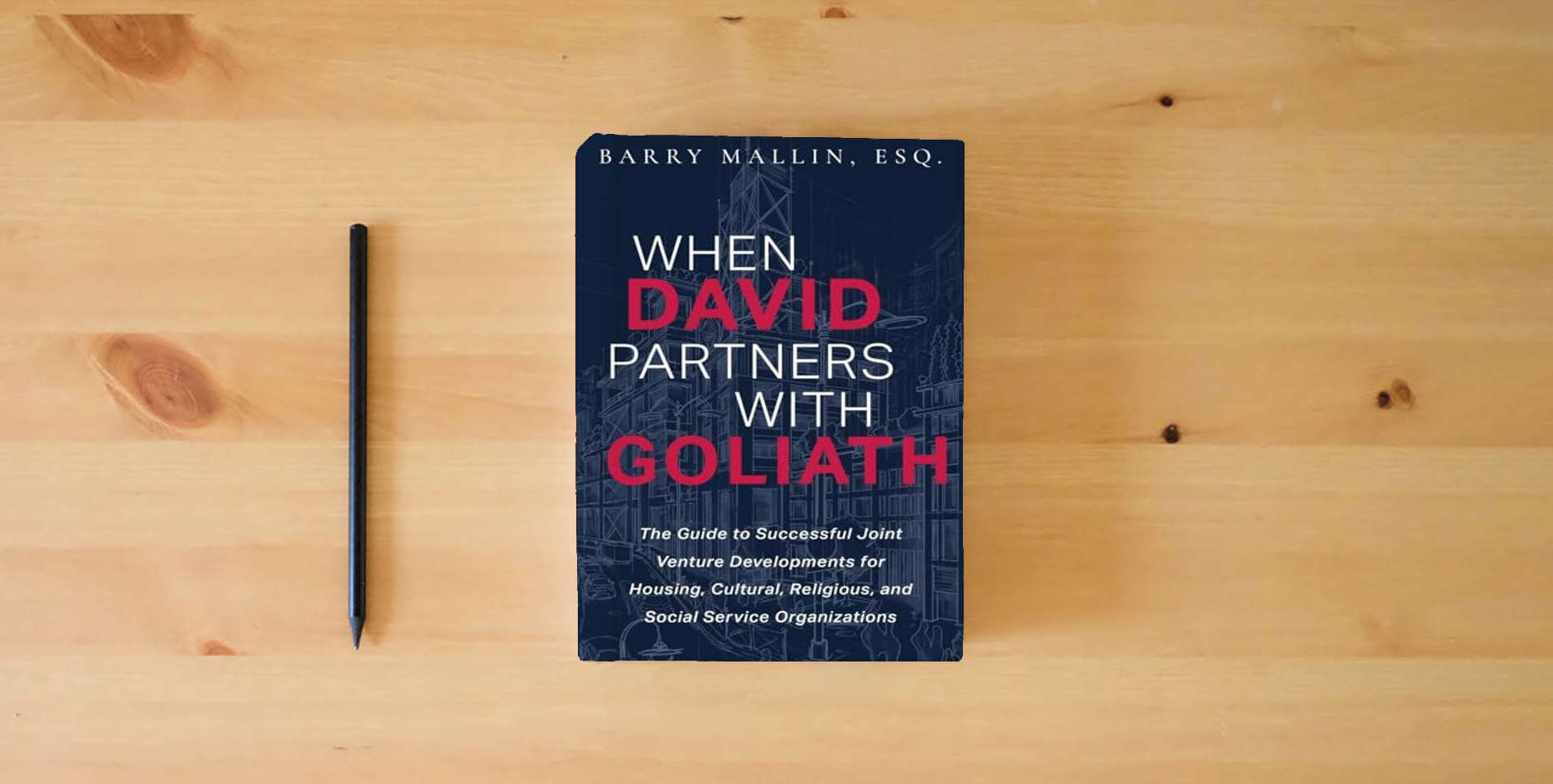 The book When David Partners with Goliath: The Guide to Successful Joint Venture Developments for Housing, Cultural, Religious, and Social Service Organizations is on the table