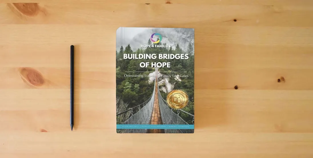 The book Building Bridges of Hope: Overcoming Trauma in the Family Court System} is on the table