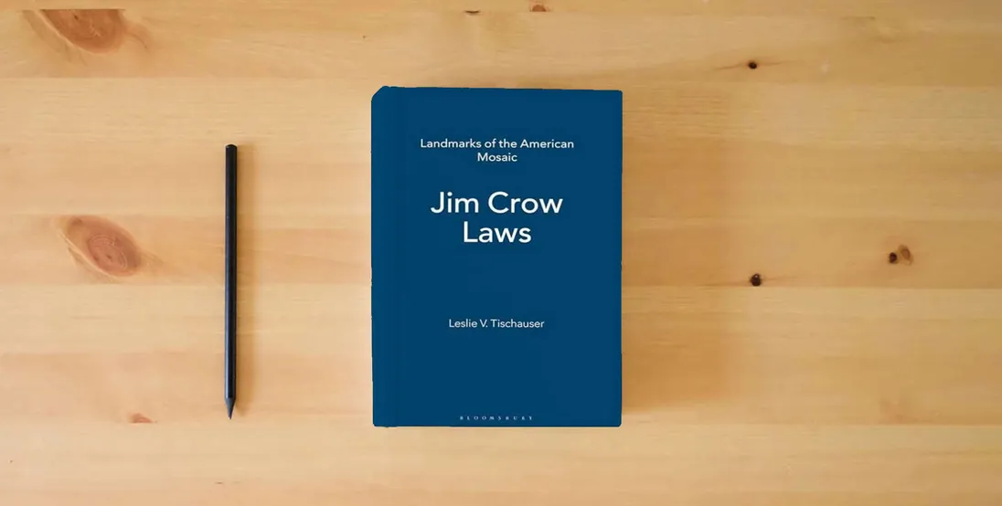 The book Jim Crow Laws (Landmarks of the American Mosaic)} is on the table