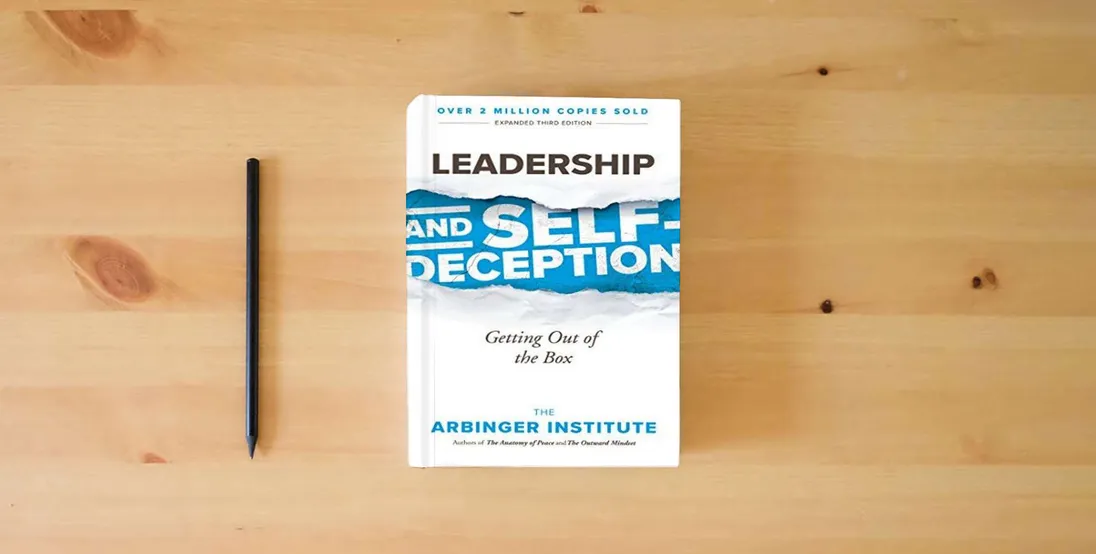 The book Leadership and Self-Deception: Getting Out of the Box} is on the table