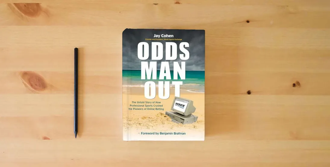 The book Odds Man Out: The Untold Story of How Professional Sports Crushed Betting's Online Pioneer} is on the table