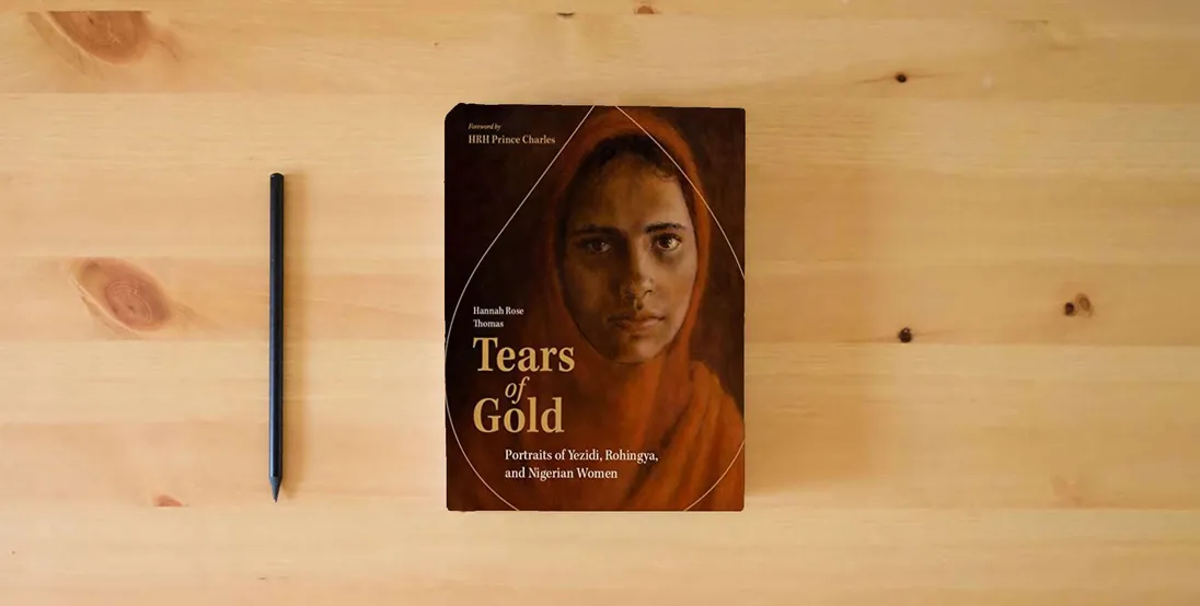 The book Tears of Gold: Portraits of Yezidi, Rohingya, and Nigerian Women} is on the table