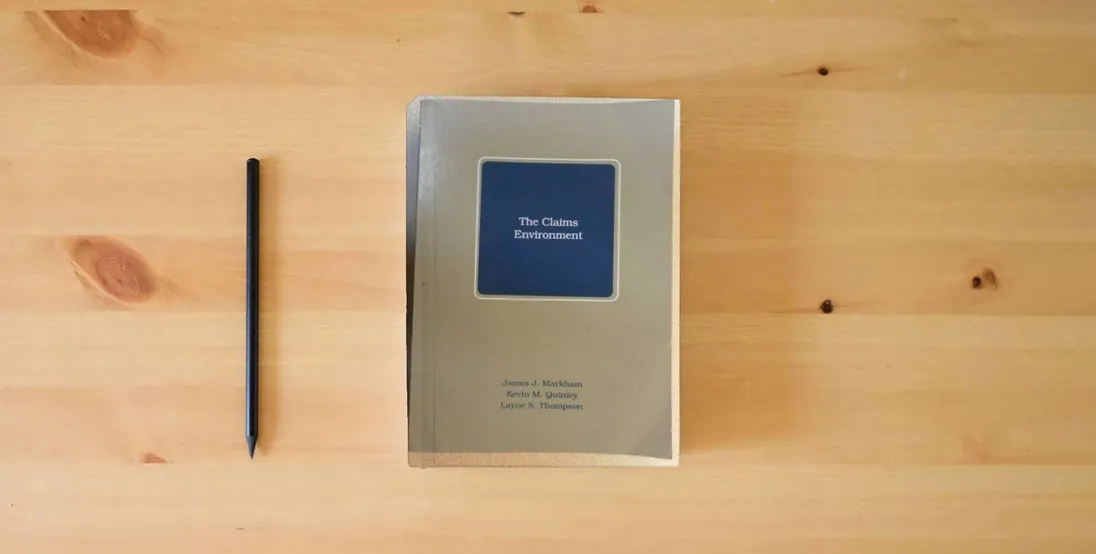 The book The Claims Environment} is on the table